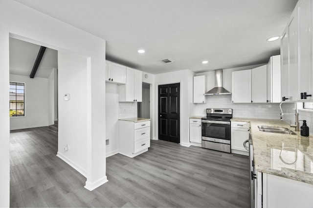 kitchen with electric range, light stone countertops, white cabinets, and wall chimney range hood