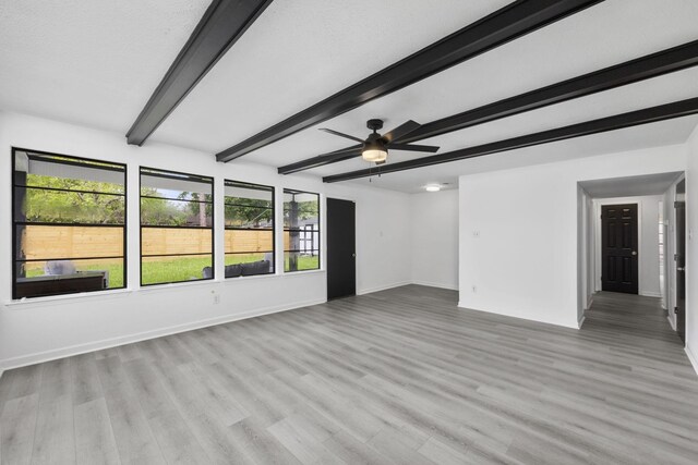 unfurnished room with beamed ceiling, light wood-type flooring, and ceiling fan