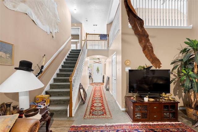 interior space featuring carpet and a towering ceiling