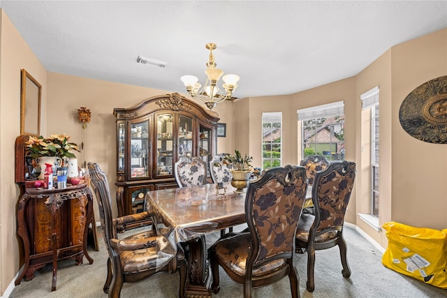 dining room with carpet flooring and a notable chandelier