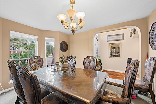 carpeted dining space with a notable chandelier