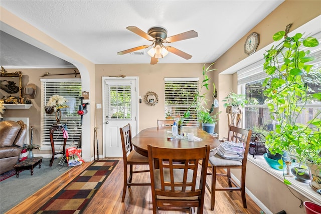 dining room with a textured ceiling, hardwood / wood-style flooring, and ceiling fan