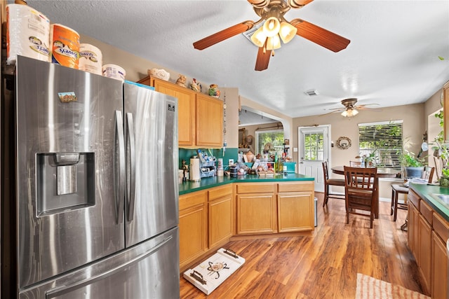 kitchen with stainless steel fridge, a textured ceiling, and hardwood / wood-style flooring