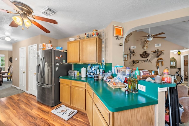 kitchen featuring a textured ceiling, ceiling fan, light hardwood / wood-style flooring, and stainless steel refrigerator with ice dispenser