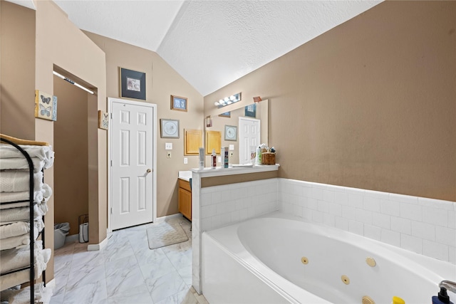 bathroom featuring vanity, lofted ceiling, and a tub