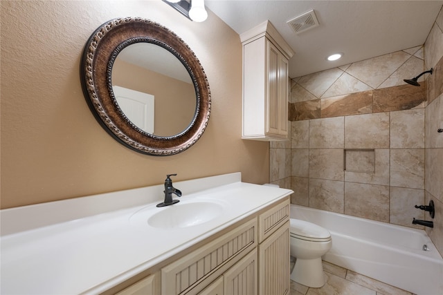 full bathroom featuring tiled shower / bath, vanity, and toilet