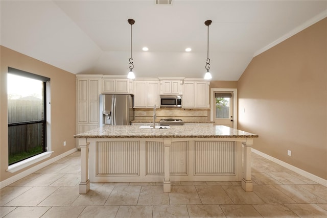 kitchen with appliances with stainless steel finishes, backsplash, lofted ceiling, and an island with sink