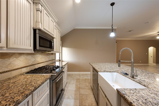 kitchen featuring sink, stainless steel appliances, tasteful backsplash, decorative light fixtures, and vaulted ceiling