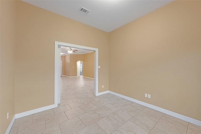 tiled spare room featuring ceiling fan