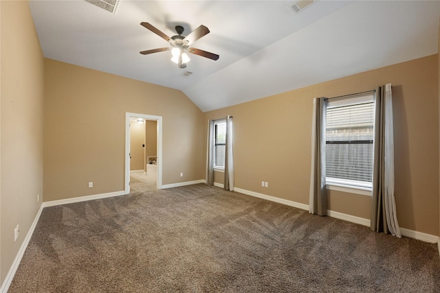 carpeted spare room with ceiling fan, plenty of natural light, and lofted ceiling