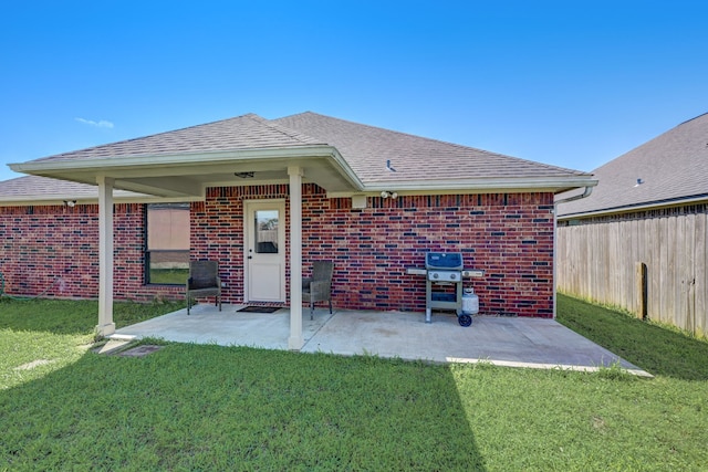 back of property with a patio area and a yard