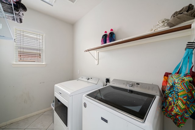 laundry area with light tile patterned floors and washing machine and clothes dryer