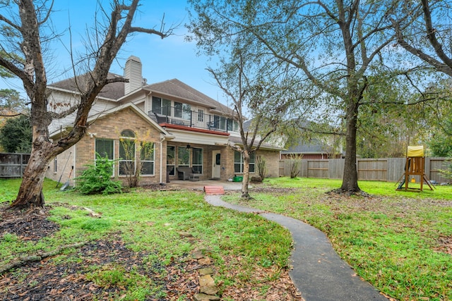 rear view of house with a playground, a patio area, a balcony, and a lawn