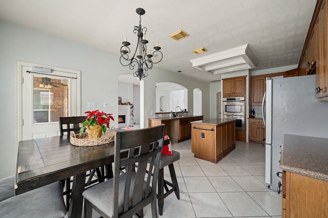 dining room with a chandelier, light tile patterned floors, and sink