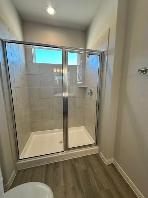 bathroom featuring hardwood / wood-style floors and a shower with shower door