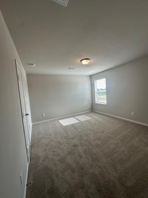 empty room with dark colored carpet