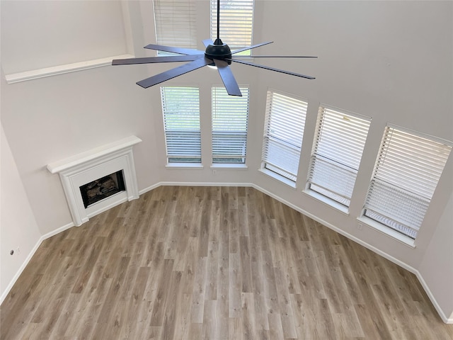 unfurnished living room with ceiling fan, light hardwood / wood-style floors, and a wealth of natural light