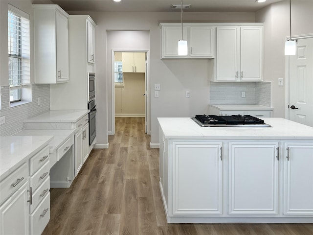 kitchen with white cabinetry, a center island, pendant lighting, and stainless steel gas cooktop