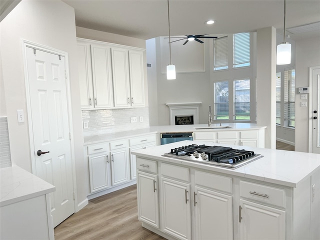 kitchen featuring sink, hanging light fixtures, white cabinetry, kitchen peninsula, and stainless steel appliances