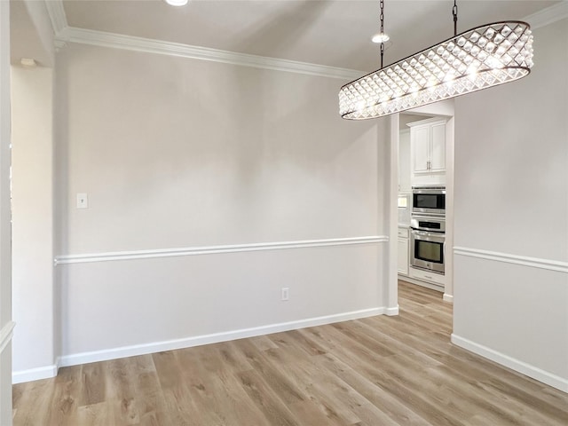 unfurnished dining area featuring light wood-type flooring and ornamental molding