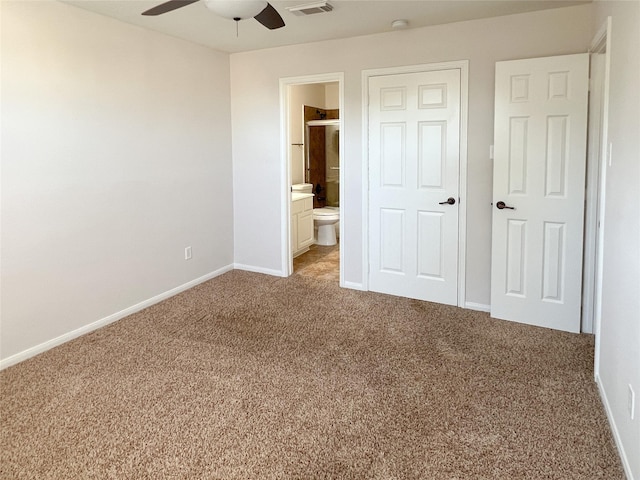 unfurnished bedroom featuring ensuite bathroom, ceiling fan, and light colored carpet