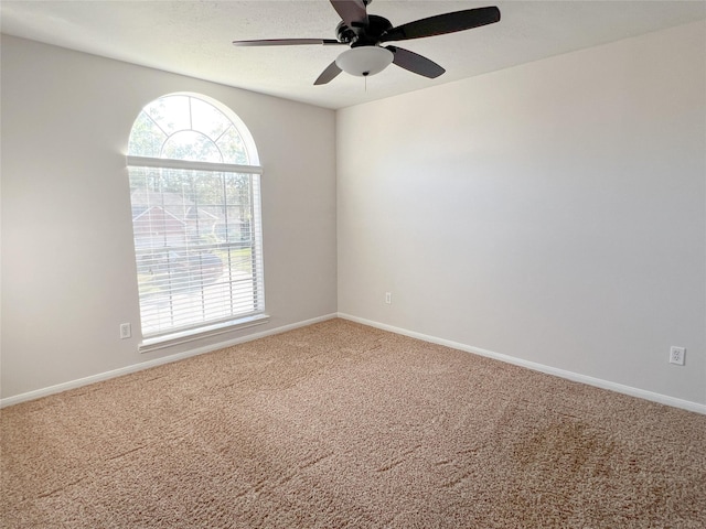 carpeted empty room featuring ceiling fan and plenty of natural light