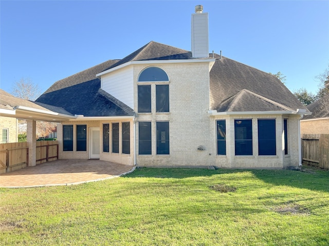 rear view of house with a patio and a lawn