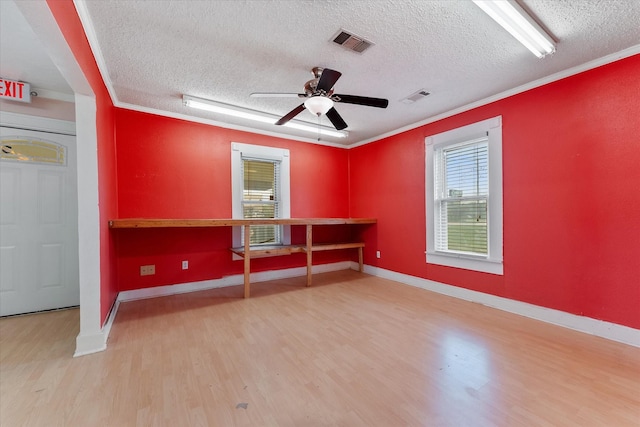 spare room with a textured ceiling, ceiling fan, crown molding, and light hardwood / wood-style flooring