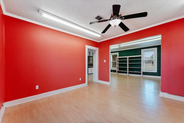 spare room with a textured ceiling, ceiling fan, light wood-type flooring, and ornamental molding