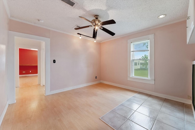 spare room with track lighting, a textured ceiling, ceiling fan, crown molding, and light hardwood / wood-style floors