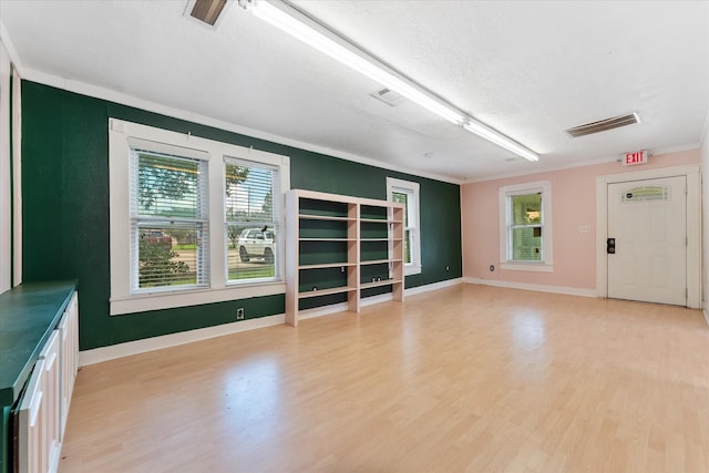 unfurnished living room with a textured ceiling, light hardwood / wood-style floors, and crown molding