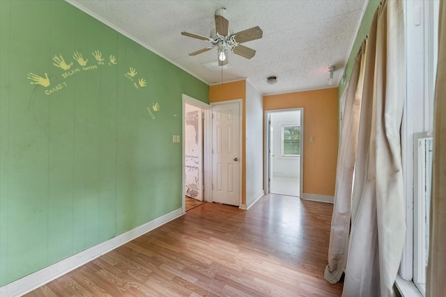 empty room featuring ceiling fan, light hardwood / wood-style floors, and a textured ceiling