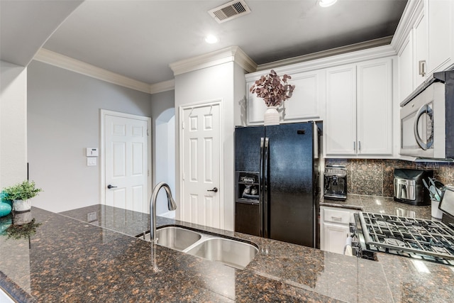 kitchen featuring white cabinets, kitchen peninsula, black fridge, and sink