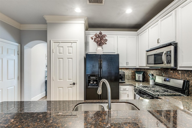 kitchen featuring white cabinetry, sink, backsplash, dark stone counters, and appliances with stainless steel finishes