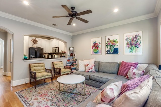 living room with ceiling fan, light hardwood / wood-style flooring, and ornamental molding