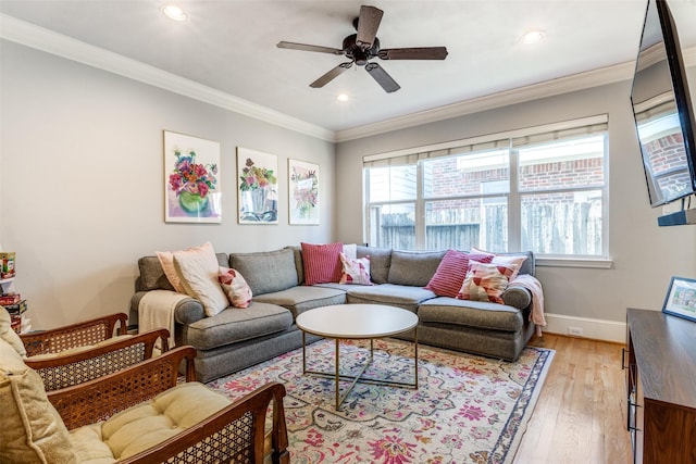 living room with light hardwood / wood-style flooring, ceiling fan, and crown molding