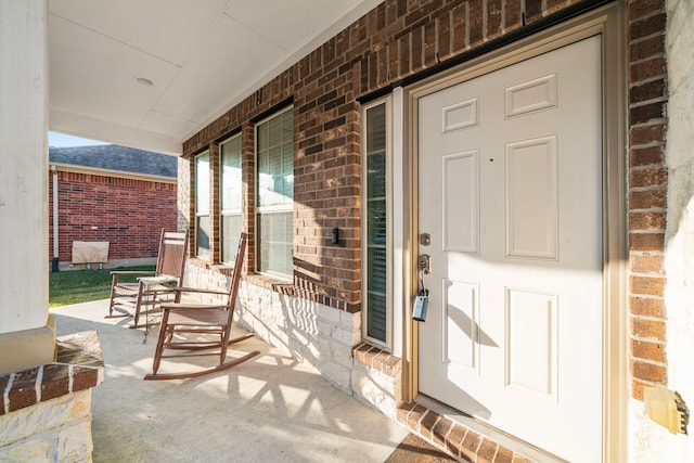 view of exterior entry featuring covered porch