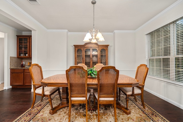 dining room featuring ornamental molding, dark hardwood / wood-style floors, and a chandelier