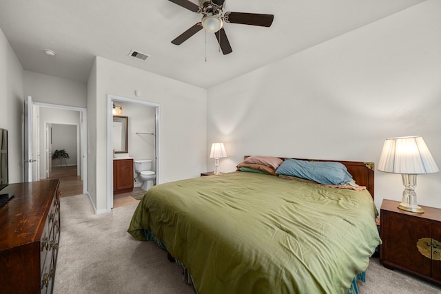 carpeted bedroom featuring ceiling fan and ensuite bathroom