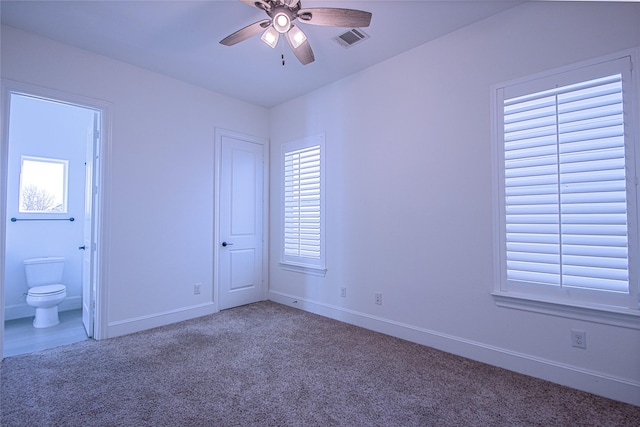 unfurnished bedroom with carpet flooring, ceiling fan, and ensuite bathroom