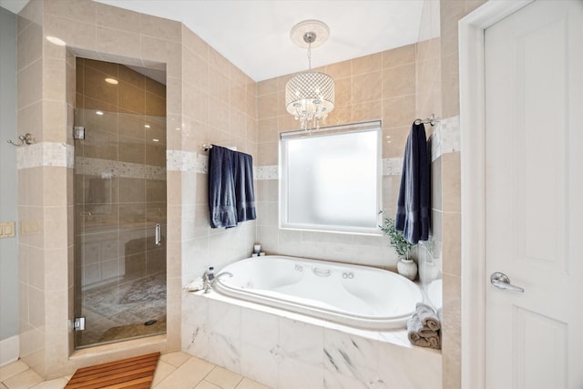 bathroom with shower with separate bathtub, tile patterned floors, and tile walls