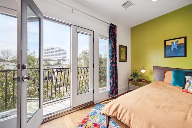 bedroom with hardwood / wood-style flooring and french doors