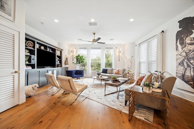 living room featuring hardwood / wood-style flooring, ceiling fan, and a wealth of natural light