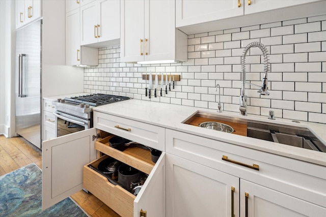 kitchen with white cabinets, sink, appliances with stainless steel finishes, and tasteful backsplash