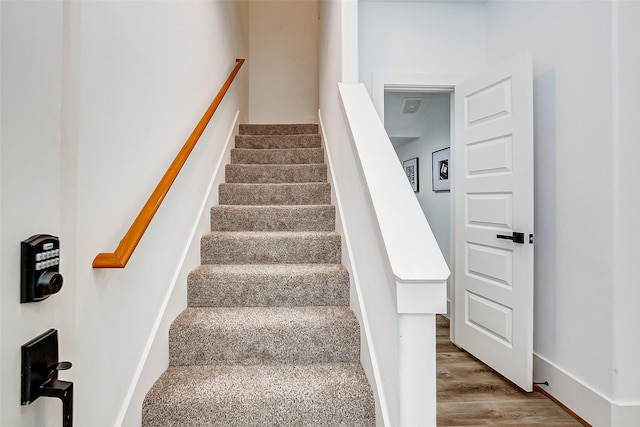 staircase with hardwood / wood-style flooring