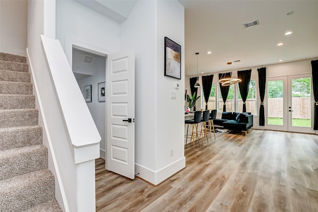 staircase featuring french doors and wood-type flooring