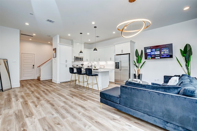 living room with light hardwood / wood-style floors and sink