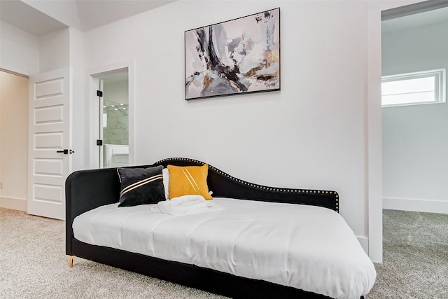 bedroom featuring light carpet and ensuite bathroom