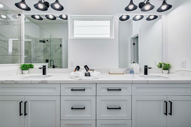 bathroom featuring a shower with door and vanity