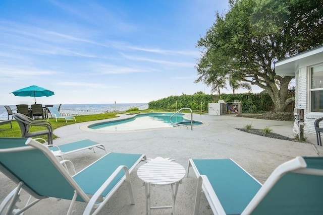 view of swimming pool with a water view and a patio